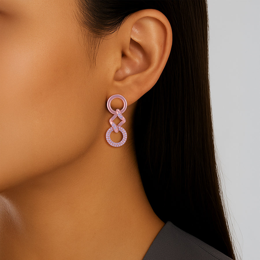 Close-up of an ear wearing a pink hoop earring with a neutral background