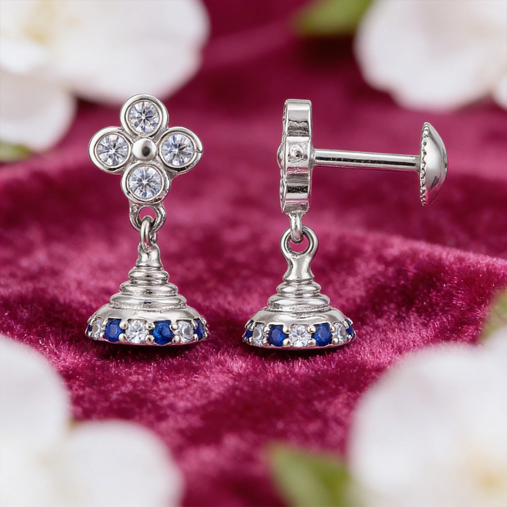 Silver earrings with gemstones on a red fabric background