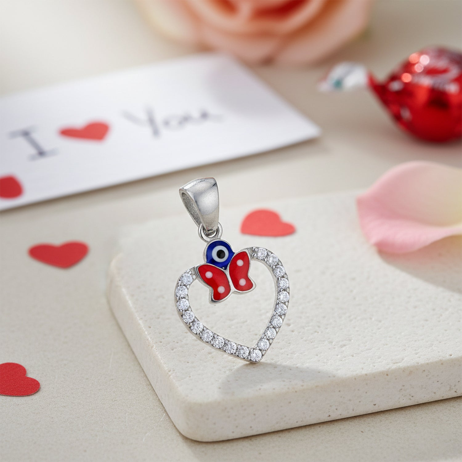 Heart-shaped pendant with butterfly design on a white surface with heart decorations.