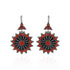 Pair of earrings with red and black floral design on a white background