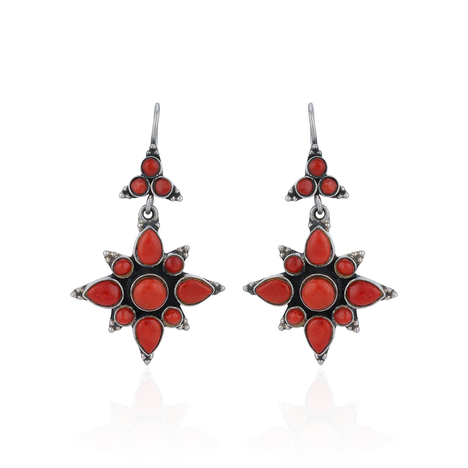 Star-shaped earrings with red stones on a white background