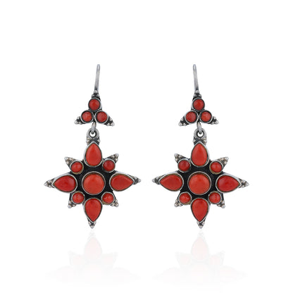 Star-shaped earrings with red stones on a white background