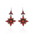 Star-shaped earrings with red stones on a white background