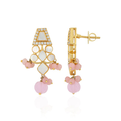 Gold and pink earrings on a white background