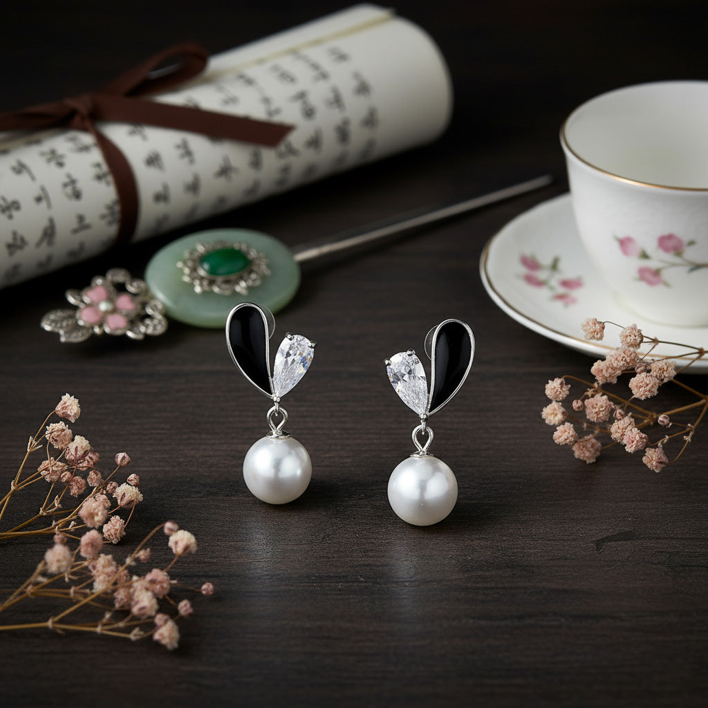 Pearl earrings on a dark surface with decorative elements