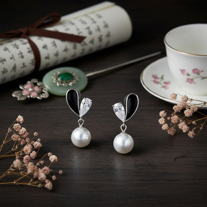 Pearl earrings on a dark surface with decorative elements