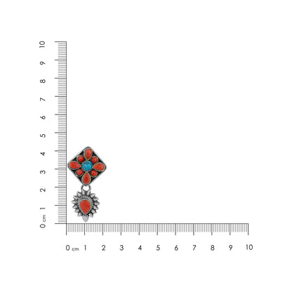 Pair of floral earrings with red and blue stones on a white background with a ruler for scale.