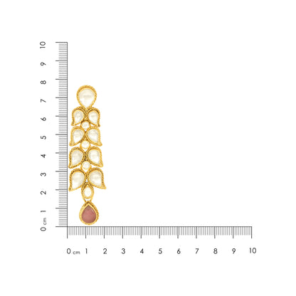 Gold and pearl earring with a ruler for scale on a white background