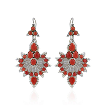 Pair of silver earrings with red stones on a white background