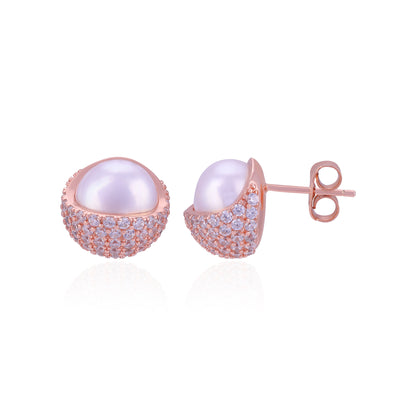 Pair of pearl earrings with rose gold and clear gemstone accents on a white background