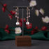 Pair of earrings on a wooden stand with a floral background