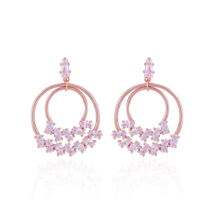 Rose gold hoop earrings with floral designs on a white background
