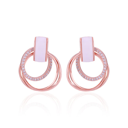 Pair of rose gold hoop earrings with pink center stones on a white background