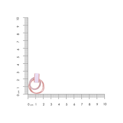 Small pink ring with a clear gemstone on a white background with a ruler for scale.