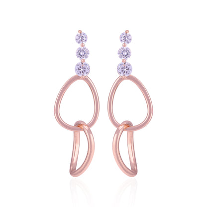 Rose gold earrings with purple gemstones on a white background