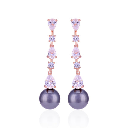 Earrings with purple pearls and rose gold accents on a white background
