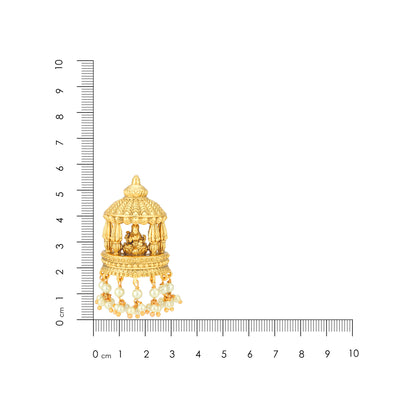 Gold pendant with intricate design next to a ruler for scale on a white background