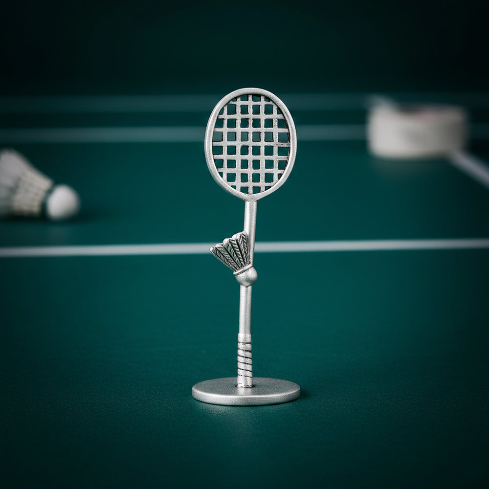 Metallic badminton racket and shuttlecock figure on a green background