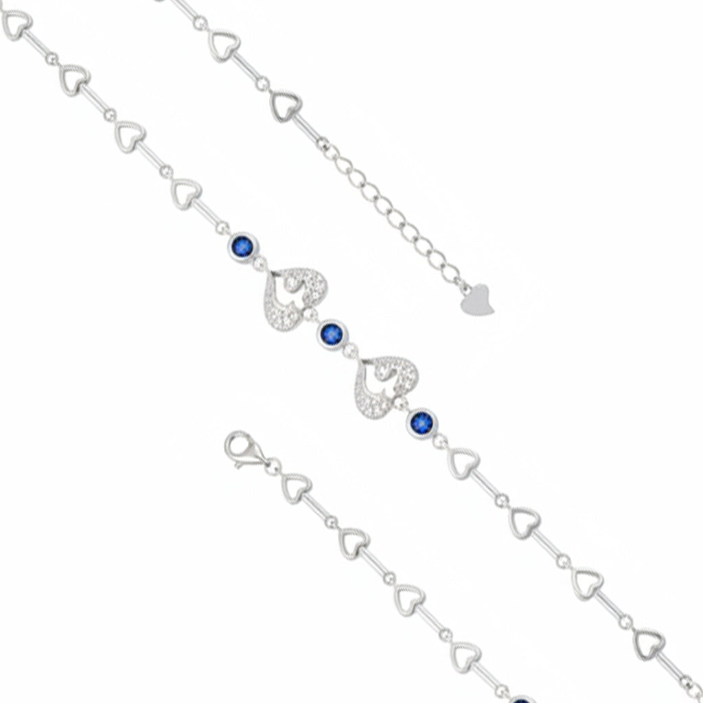 Silver bracelet with heart-shaped links and blue gemstones on a white background