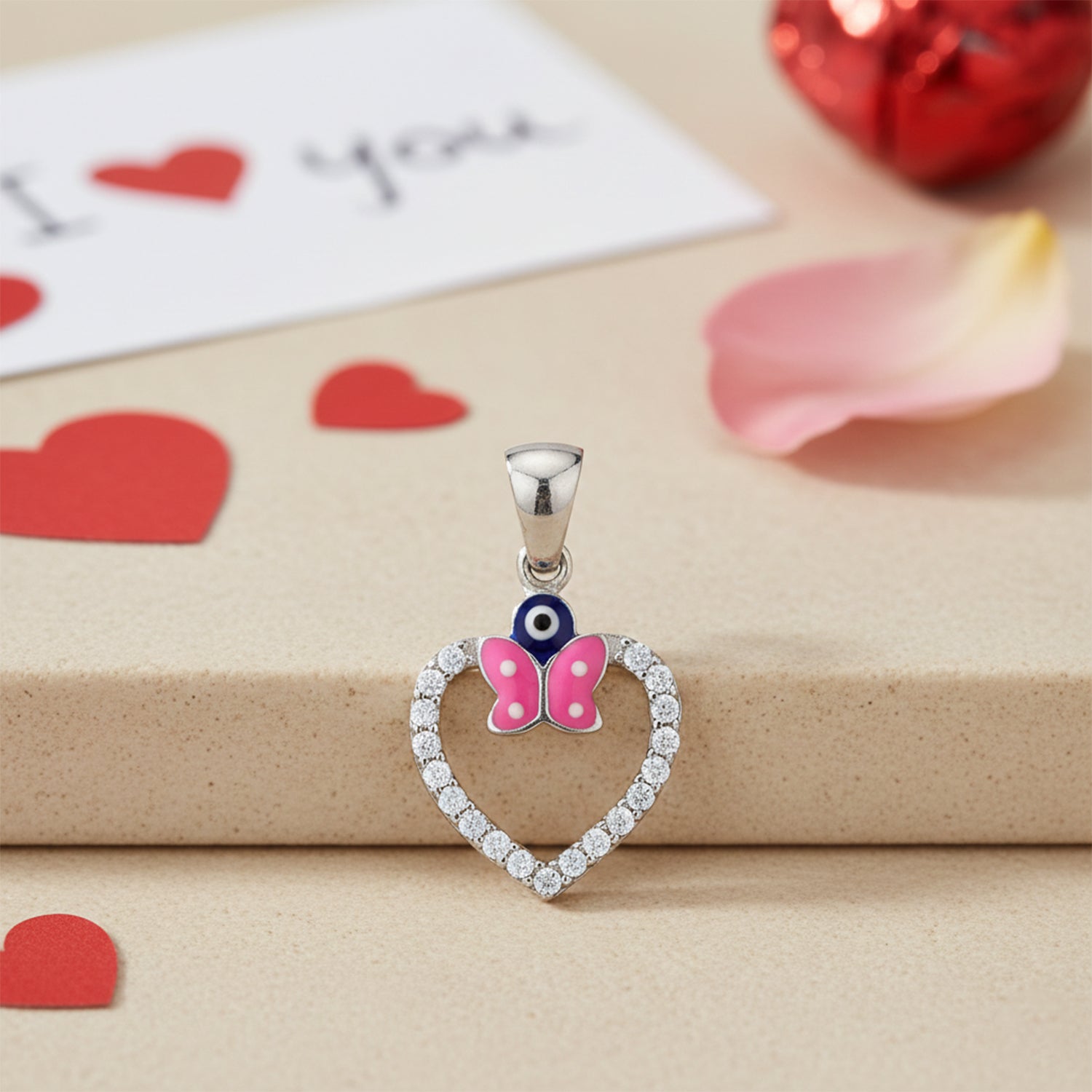 Heart-shaped pendant with a butterfly design on a beige surface with heart decorations.