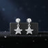 Silver star-shaped earrings on a dark background