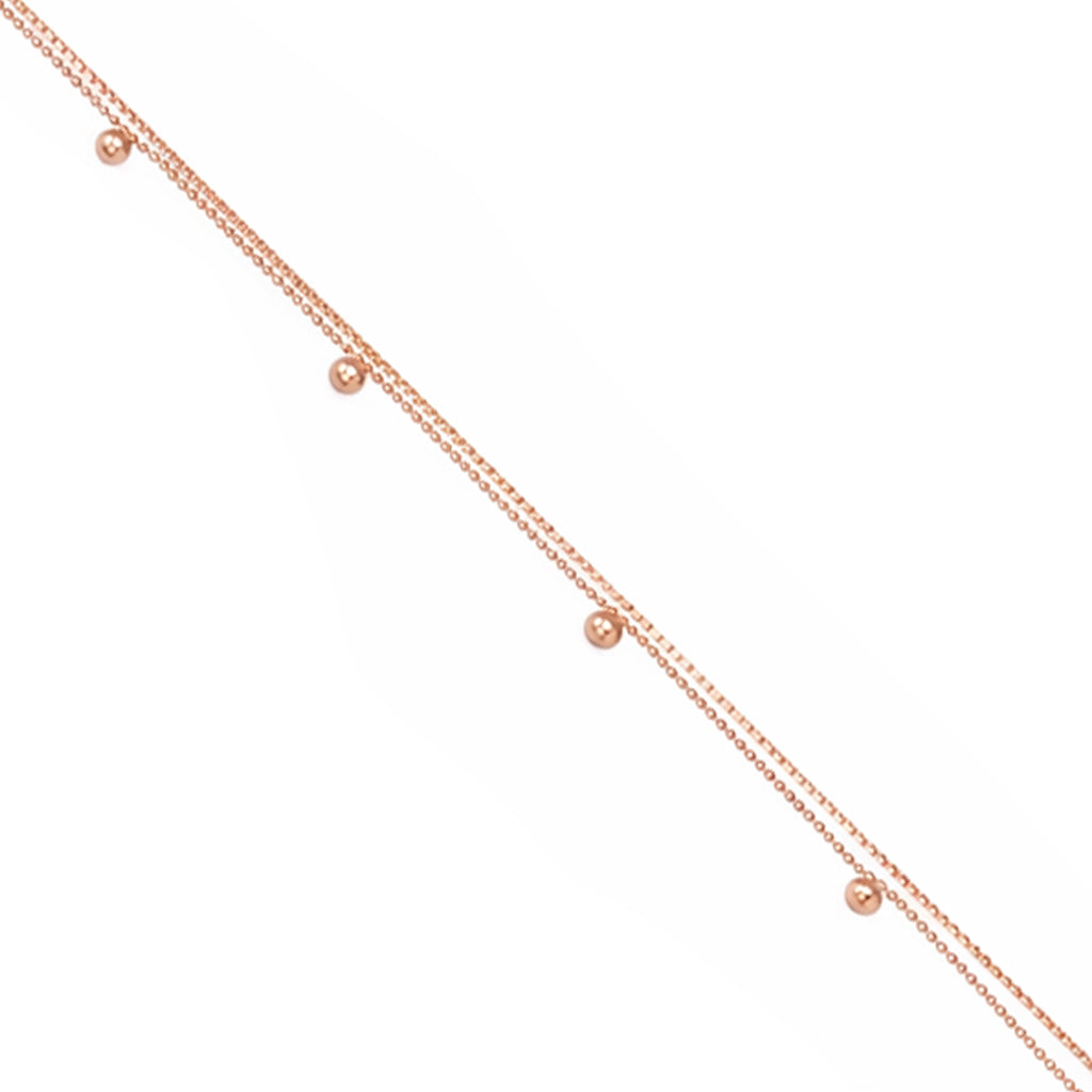 Rose gold necklace with small beads on a white background