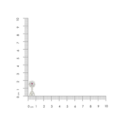 Small green and orange object next to a ruler on a white background