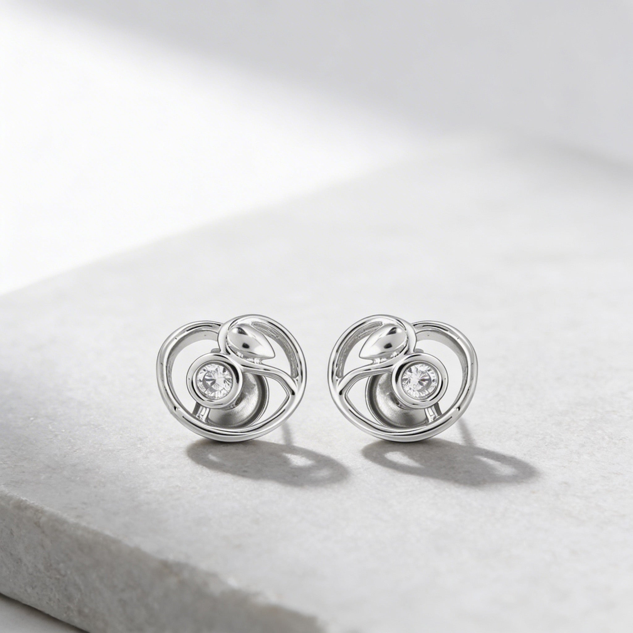 Pair of silver earrings with circular design on a light gray background