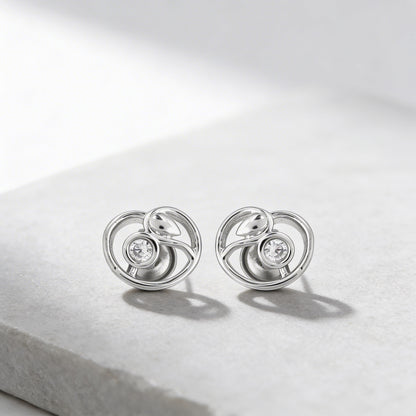 Pair of silver earrings with circular design on a light gray background