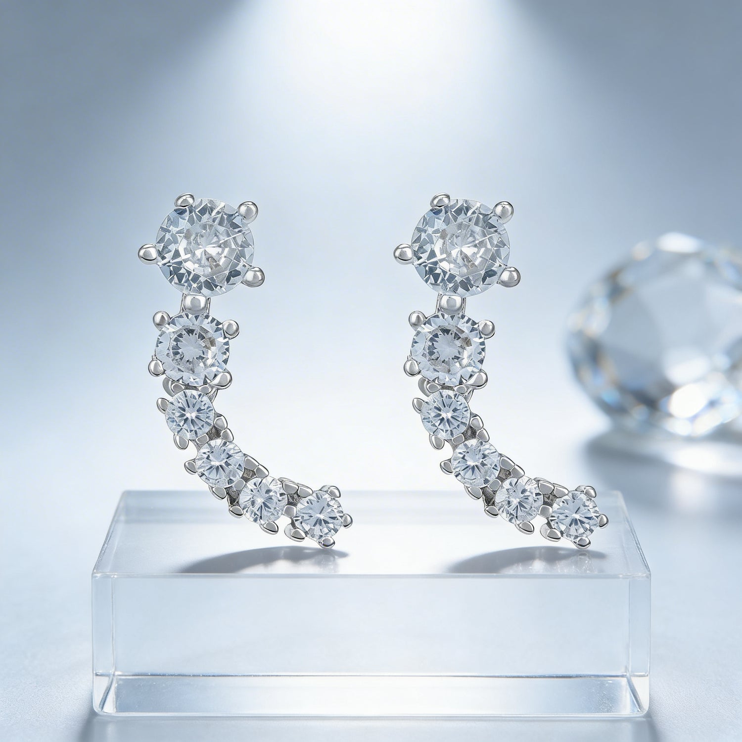 Diamond earrings on a clear stand with a light gray background