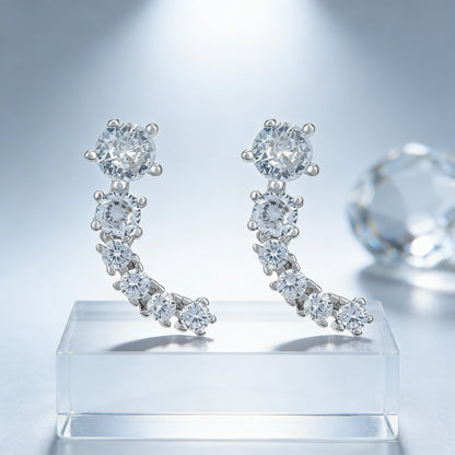 Diamond earrings on a clear stand with a light gray background
