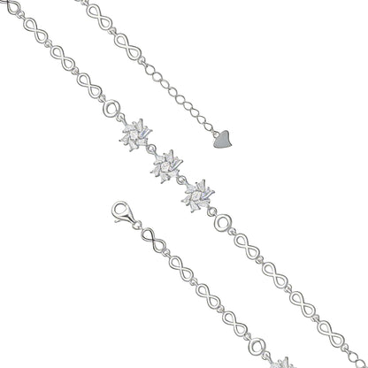 Silver bracelet with heart and infinity symbols on a pink fabric background