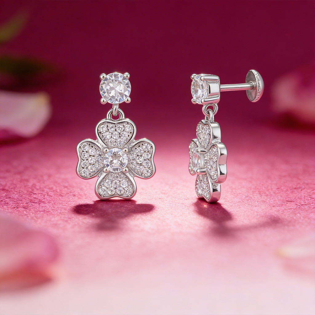 Silver earrings with floral design on a pink background