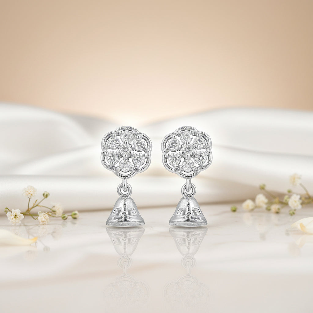 Silver earrings with floral design on a soft fabric background