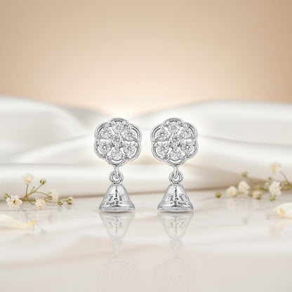 Silver earrings with floral design on a soft fabric background