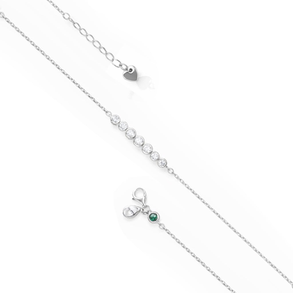 Silver necklace with a small green gemstone pendant on a white background