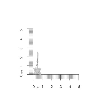 Silver earring with crown design next to a ruler for scale on a white background