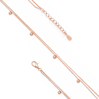 Rose gold necklace with small beads on a white background