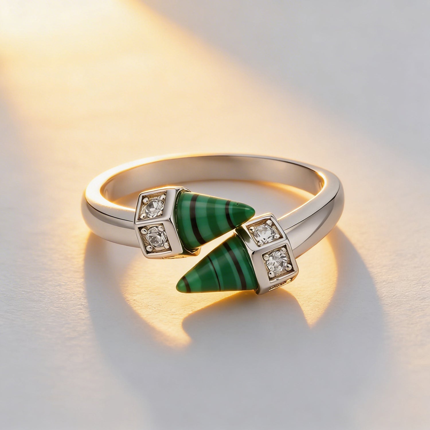 Gold ring with green gemstone and diamonds on a light background
