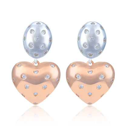 Heart-shaped earrings with rose gold and silver finishes on a white background