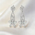Pair of silver earrings with gemstones on a light background
