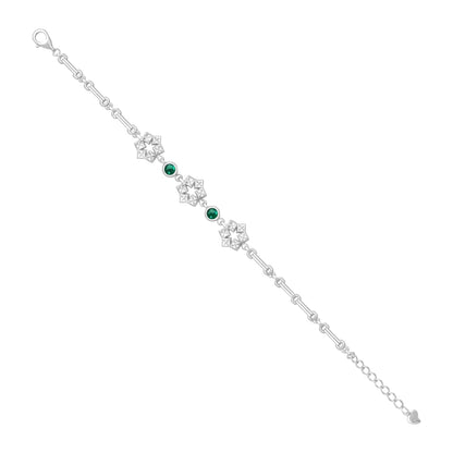 Silver bracelet with floral designs and green gemstones on a white background