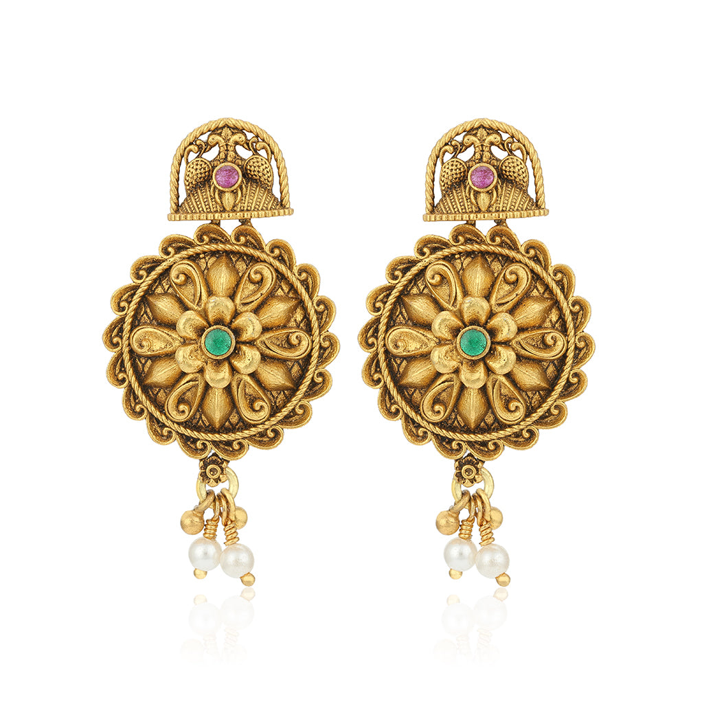 Ornate gold earrings with floral designs and gemstones on a white background