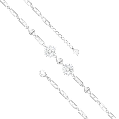 Silver bracelet with heart and snowflake charms on a white background