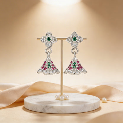 Pair of earrings with gemstones on a marble stand against a beige background