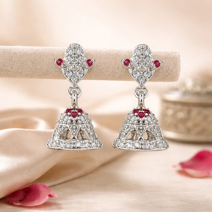 Silver earrings with red gemstones on a soft beige background