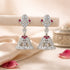 Silver earrings with red gemstones on a soft beige background