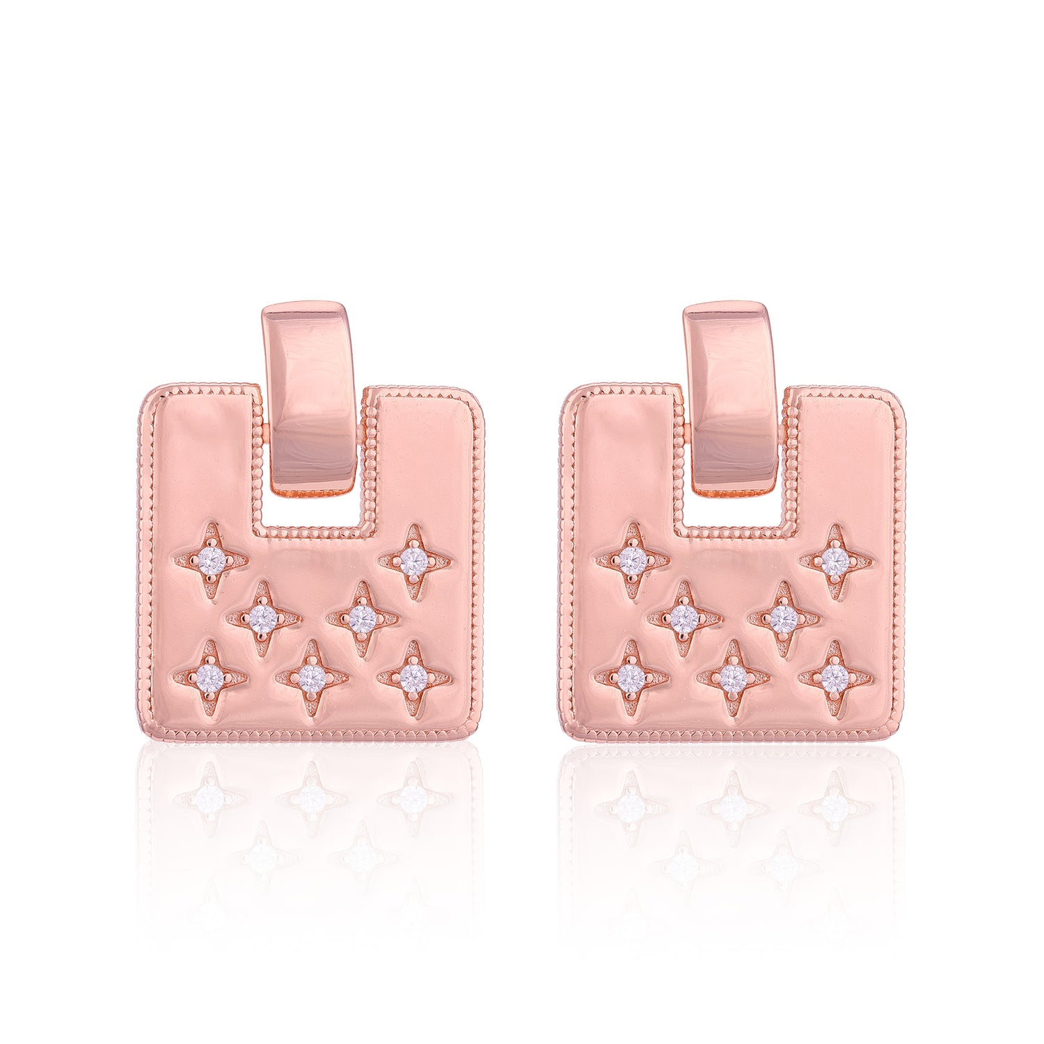 Pair of pink earrings with star designs on a white background