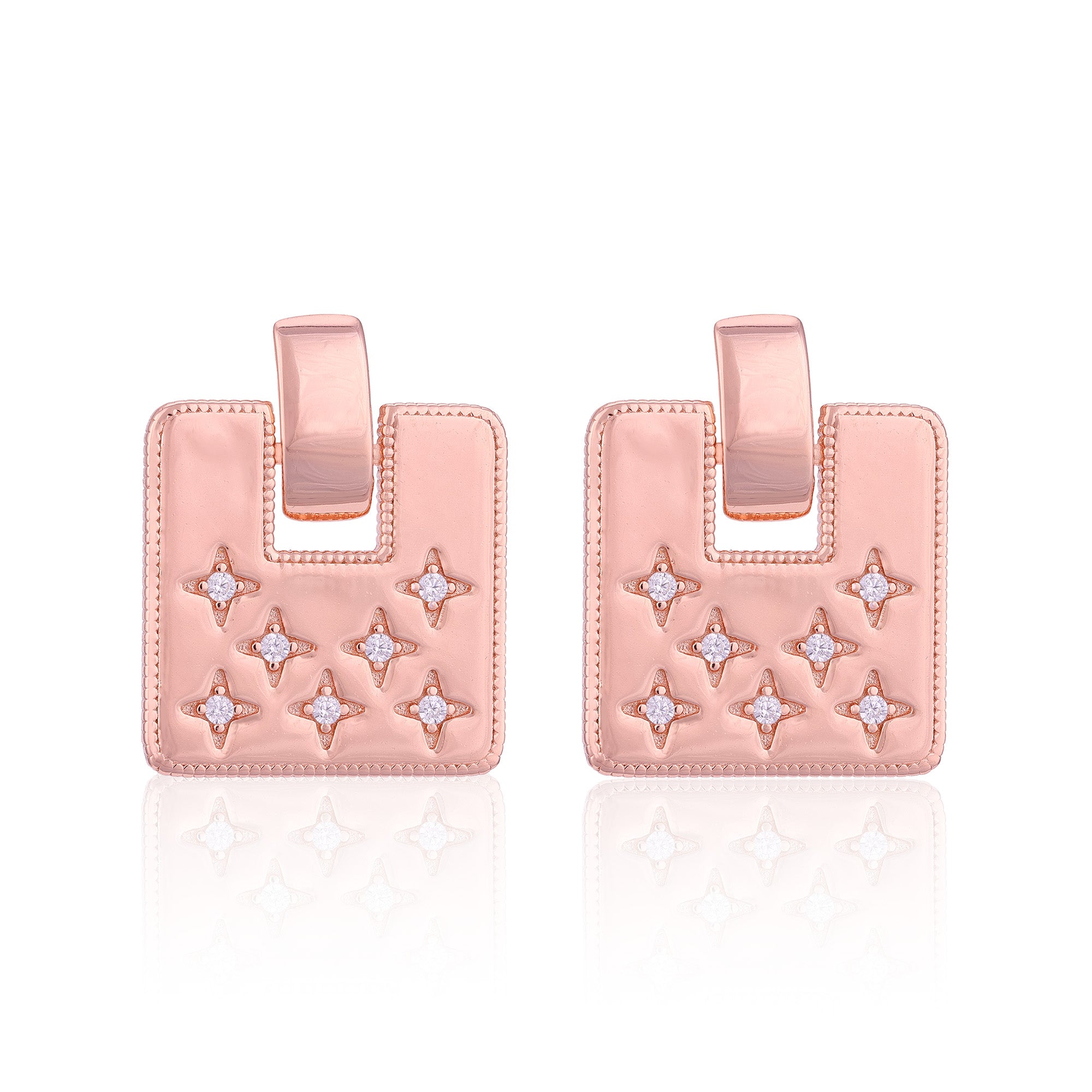 Pair of pink earrings with star designs on a white background