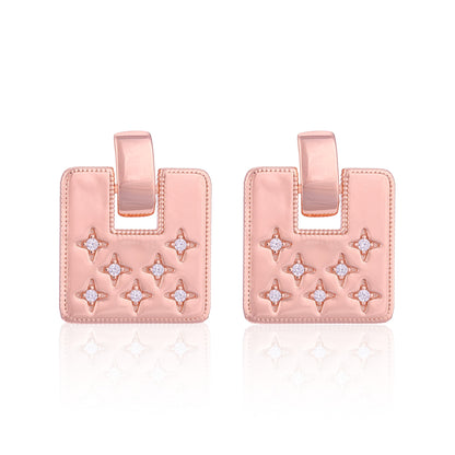 Pair of pink earrings with star designs on a white background